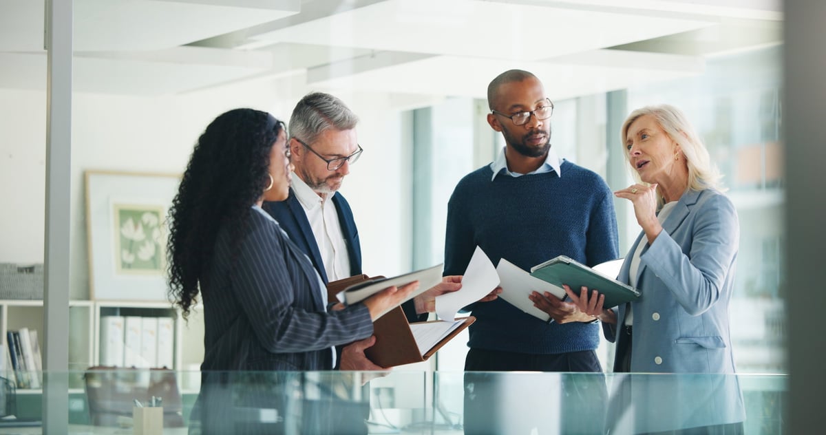 Financial advisors reviewing trends and reports together in a meeting